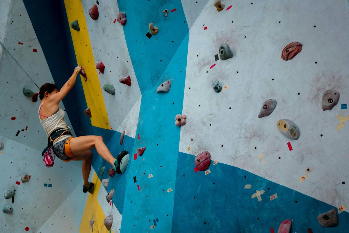 Climber adjusting climbing gear to wear with certified helmet on limestone route