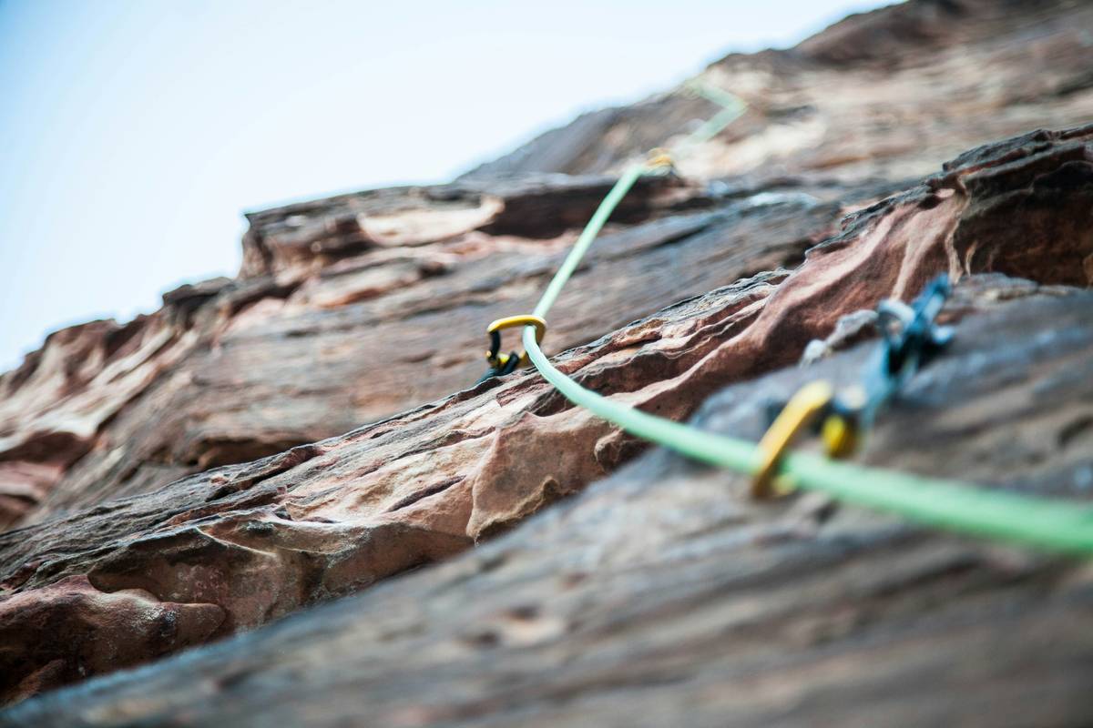 climber inspecting used climbing helmet for how to get climbing gear temtem